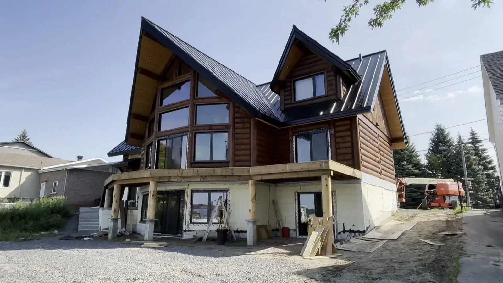 A timber home under construction with a tall glazed facade