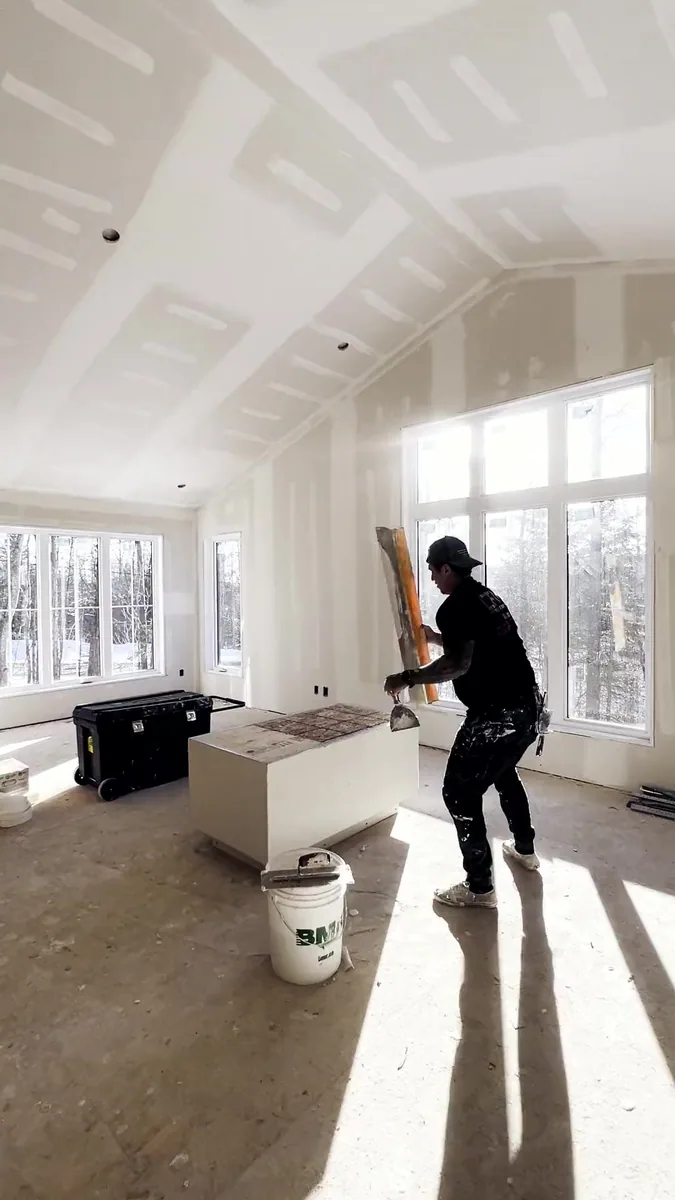 A CFM craftsperson finishing a bright room with large windows
